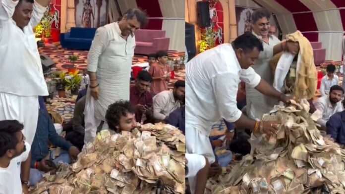 Singer buried under a pile of currency notes while singing bhajans, video from Dwarka goes viral on the internet Singer buried under a pile of currency notes while singing bhajans, video from Dwarka goes viral on the internet
