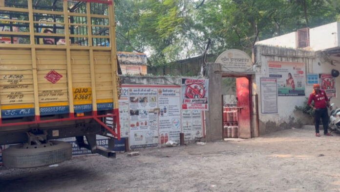दो ट्रकों के बीच फंसा कर्मचारी, हालत गंभीर